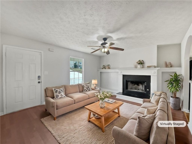 living room with ceiling fan and a textured ceiling