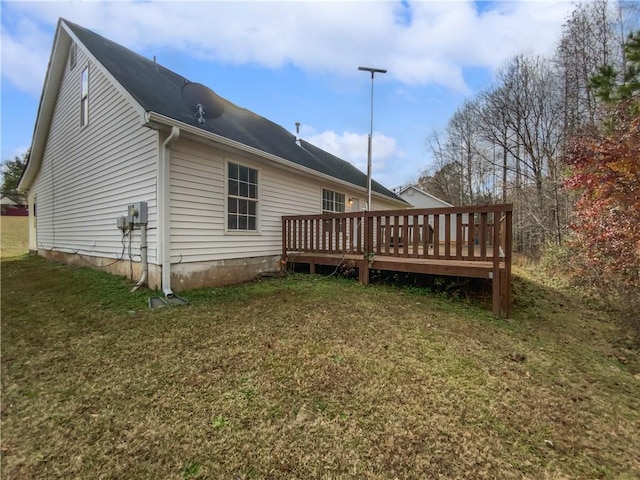 rear view of house with a lawn and a wooden deck