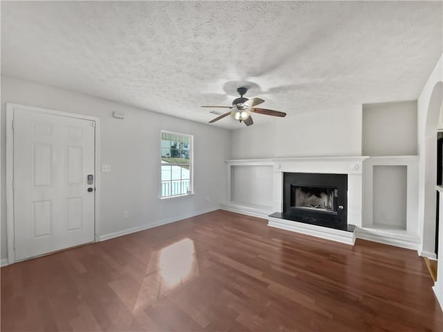 unfurnished living room with ceiling fan, a textured ceiling, and hardwood / wood-style flooring