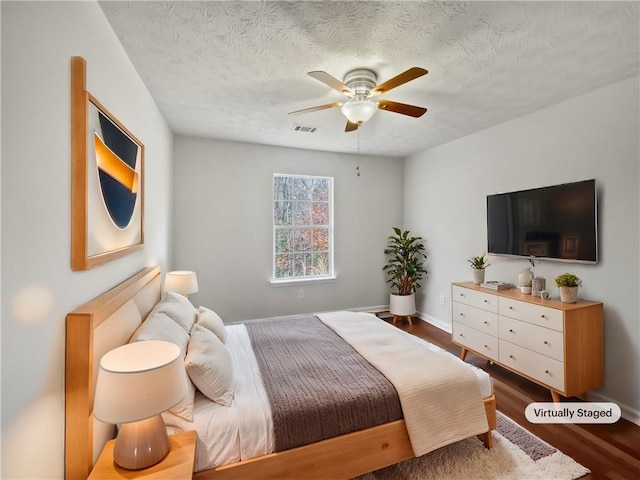 bedroom featuring hardwood / wood-style floors, a textured ceiling, and ceiling fan