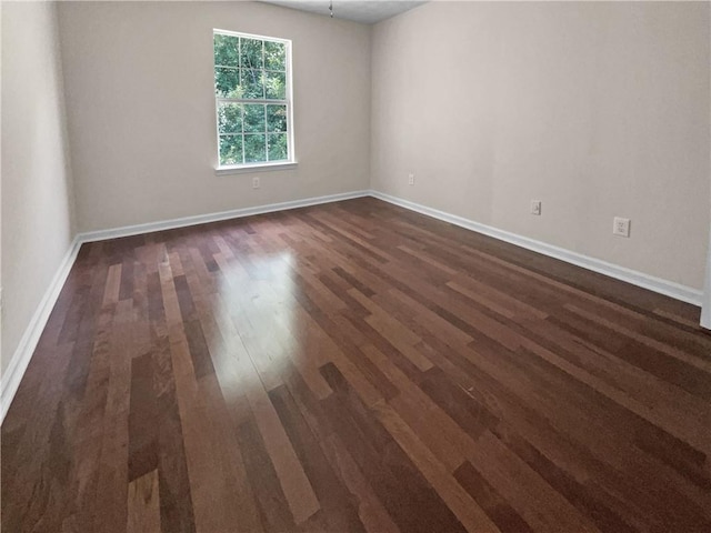 unfurnished room with dark wood-type flooring