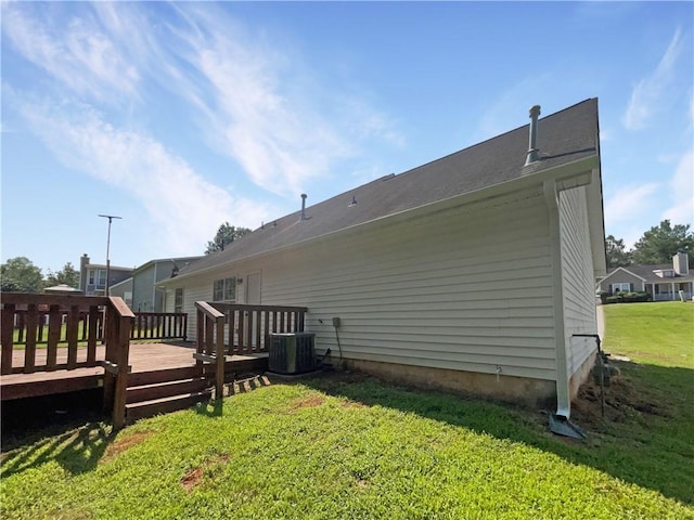 back of house featuring a lawn, a wooden deck, and central AC unit