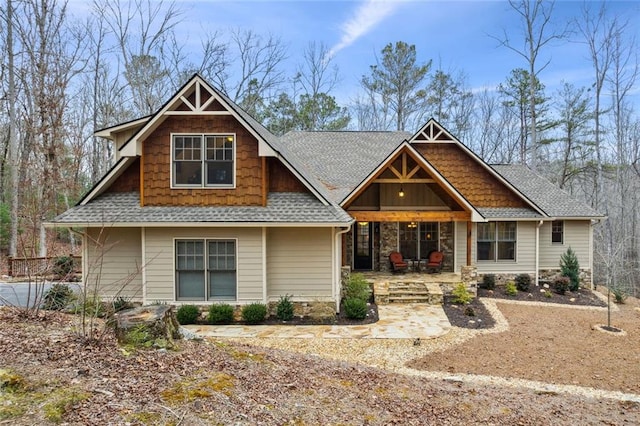 craftsman-style house featuring a patio area and a shingled roof