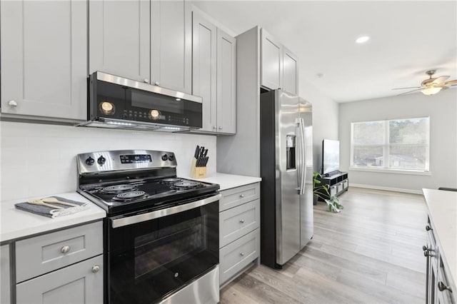 kitchen featuring stainless steel appliances, tasteful backsplash, light countertops, gray cabinetry, and light wood-style floors