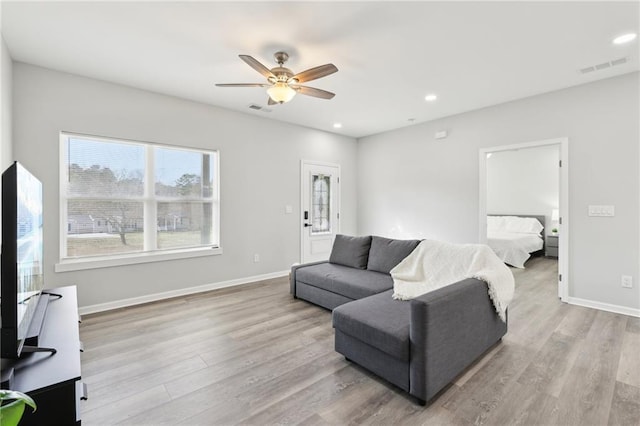 living room with visible vents, baseboards, and wood finished floors