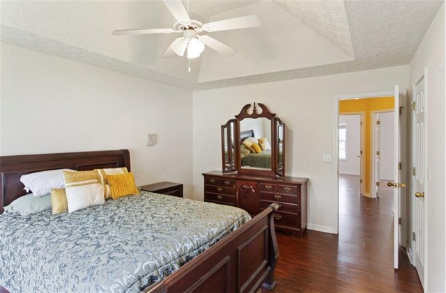 3971 Canebrake Ln, Douglasville, GA 30134 - bedroom with dark wood-style flooring, baseboards, a textured ceiling, ceiling fan, and a tray ceiling