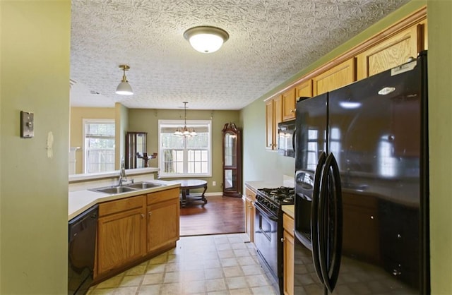 3971 Canebrake Ln, Douglasville, GA 30134 - kitchen featuring black appliances, a sink, a chandelier, pendant lighting, and brown cabinets