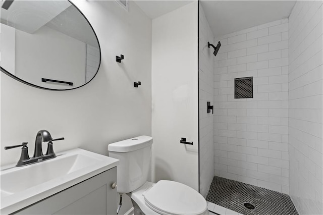 bathroom featuring tiled shower, vanity, and toilet