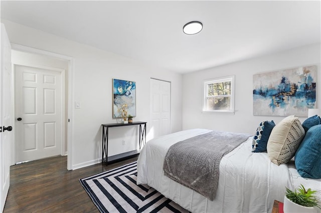 bedroom with dark wood-type flooring and a closet