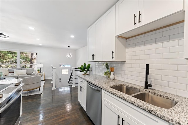 kitchen featuring decorative backsplash, light stone counters, stainless steel appliances, sink, and white cabinets