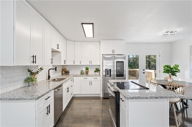 kitchen with appliances with stainless steel finishes, backsplash, white cabinetry, and sink