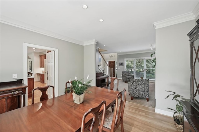 dining room with stairs, crown molding, baseboards, recessed lighting, and light wood-style flooring