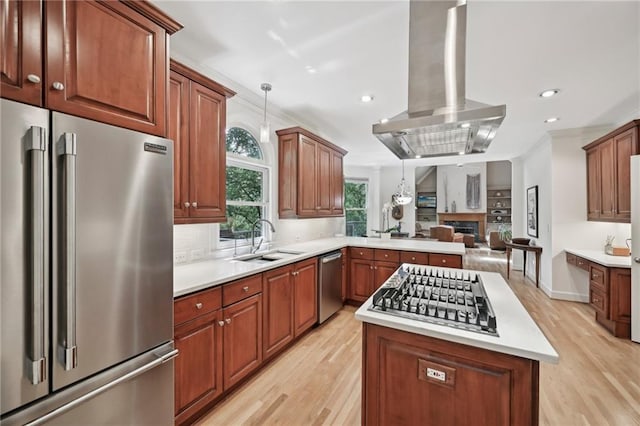 kitchen featuring stainless steel appliances, light wood-style flooring, a sink, island exhaust hood, and a center island