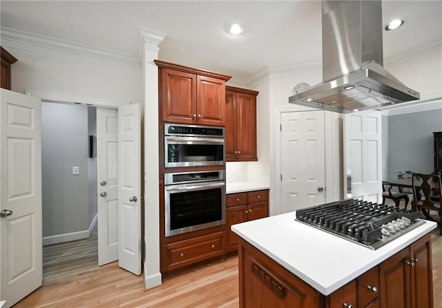 kitchen featuring island exhaust hood, stainless steel appliances, ornamental molding, light wood-style floors, and light countertops