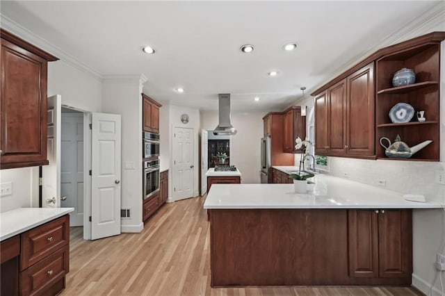 kitchen with island exhaust hood, high end refrigerator, a peninsula, tasteful backsplash, and recessed lighting