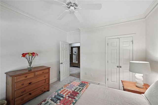 bedroom featuring ornamental molding, baseboards, carpet floors, a ceiling fan, and a closet