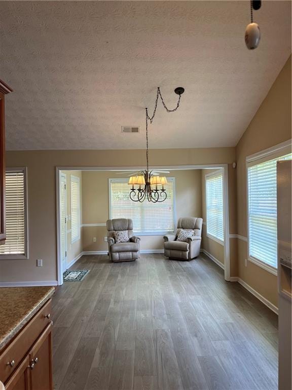 964 Village View Cir, Loganville, GA 30052 - sitting room featuring dark wood-style flooring, a textured ceiling, baseboards, a chandelier, and lofted ceiling