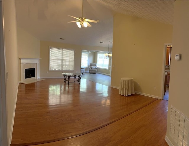 964 Village View Cir, Loganville, GA 30052 - unfurnished living room featuring lofted ceiling, ceiling fan, wood finished floors, a fireplace with flush hearth, and baseboards