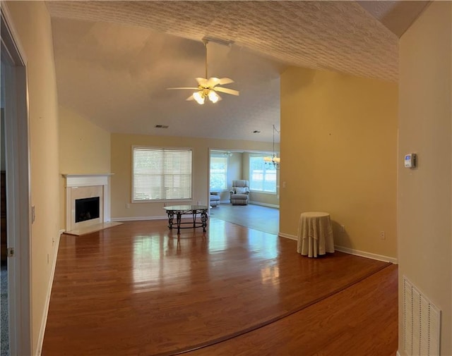 964 Village View Cir, Loganville, GA 30052 - living area featuring wood finished floors, a ceiling fan, a fireplace with flush hearth, vaulted ceiling, and baseboards