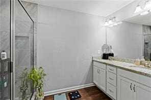 6547 River Station Dr, Lula, GA 30554 - bathroom with double vanity, a stall shower, wood finished floors, and baseboards