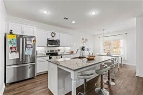 6547 River Station Dr, Lula, GA 30554 - kitchen with stainless steel appliances, a sink, a kitchen bar, a center island with sink, and white cabinets
