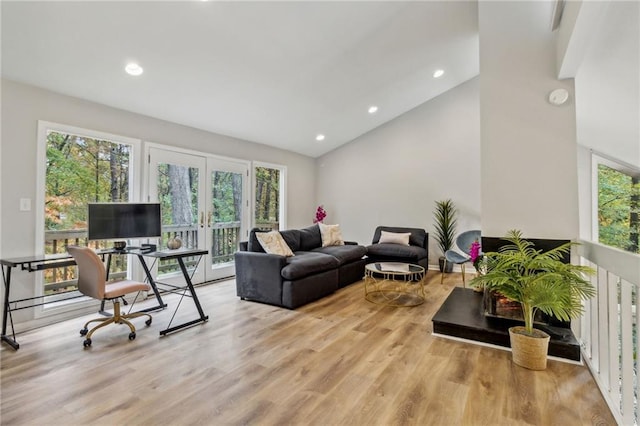 living room featuring a wealth of natural light, french doors, and light hardwood / wood-style floors