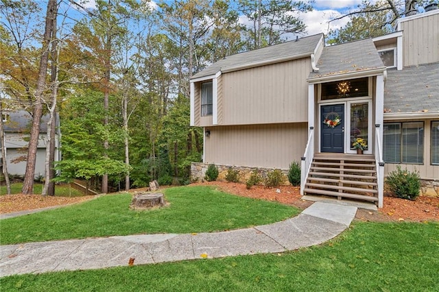 view of exterior entry with a lawn