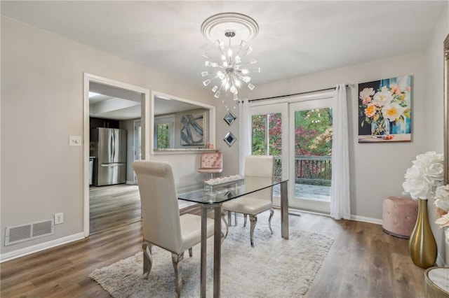 dining space with a notable chandelier and hardwood / wood-style flooring