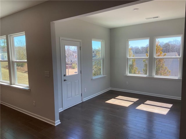 foyer with visible vents, a healthy amount of sunlight, and dark wood-style flooring