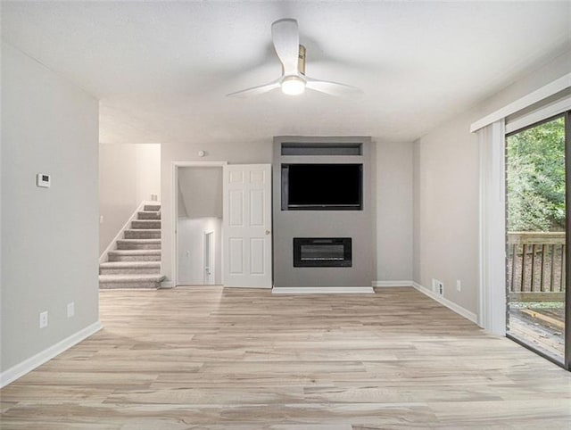 2544 Peyton Woods Trl SW, Atlanta, GA 30311 - unfurnished living room with a ceiling fan, light wood-style flooring, baseboards, and stairway