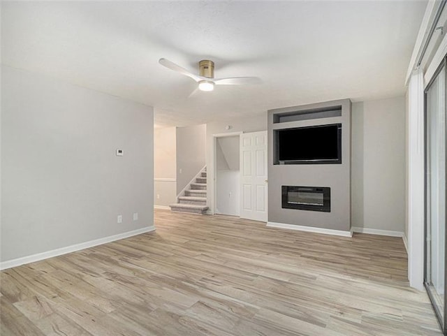 2544 Peyton Woods Trl SW, Atlanta, GA 30311 - unfurnished living room featuring a ceiling fan, a glass covered fireplace, stairs, and baseboards