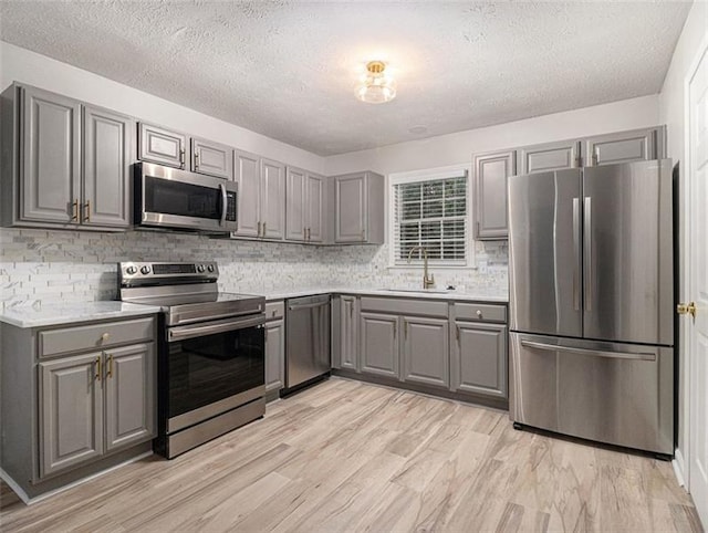 2544 Peyton Woods Trl SW, Atlanta, GA 30311 - kitchen with stainless steel appliances, gray cabinetry, a sink, and a textured ceiling