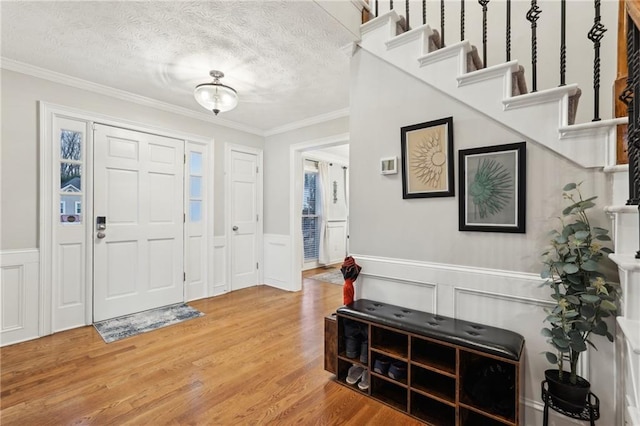 entryway featuring hardwood / wood-style floors, a textured ceiling, and ornamental molding