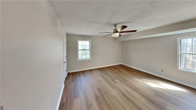 unfurnished room featuring ceiling fan, wood finished floors, and baseboards