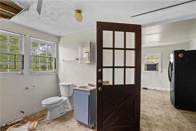 bathroom with toilet, a textured ceiling, cooling unit, and vanity