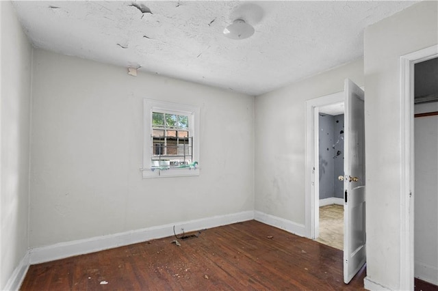 unfurnished bedroom featuring baseboards, wood finished floors, and a closet