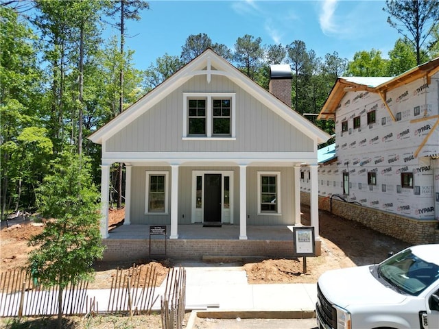 view of front of house with a chimney and a porch