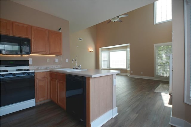 kitchen with a wealth of natural light, sink, kitchen peninsula, and black appliances