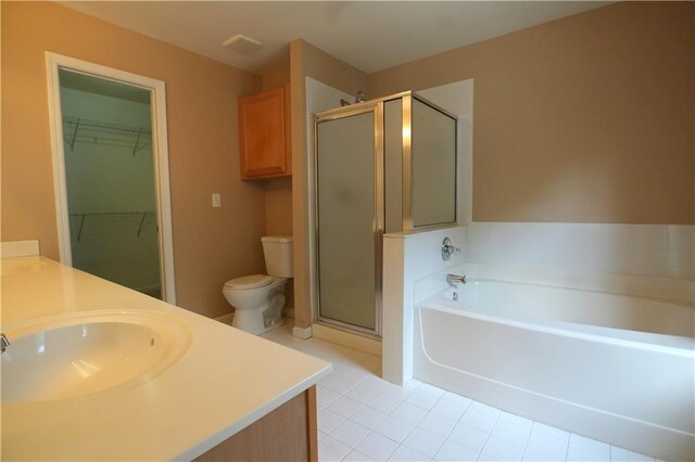 full bathroom featuring toilet, vanity, separate shower and tub, and tile patterned floors