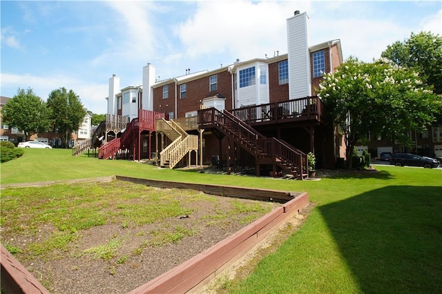 view of playground with a lawn and a wooden deck