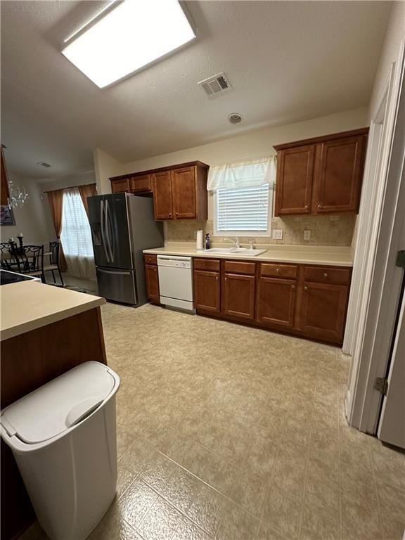 kitchen with stainless steel refrigerator with ice dispenser, dishwasher, and sink