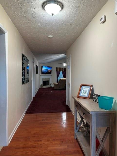 corridor featuring dark hardwood / wood-style floors and a textured ceiling