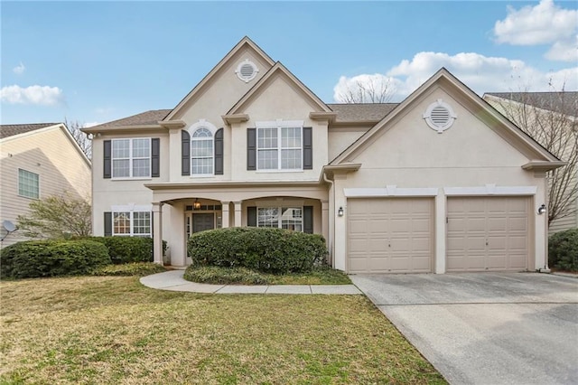 traditional-style house with stucco siding, an attached garage, concrete driveway, and a front yard