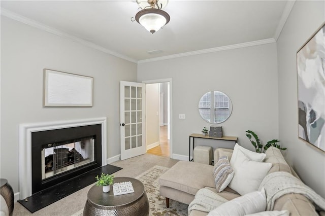 carpeted living area with crown molding, a fireplace with raised hearth, and baseboards