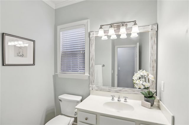 bathroom with toilet, vanity, and crown molding