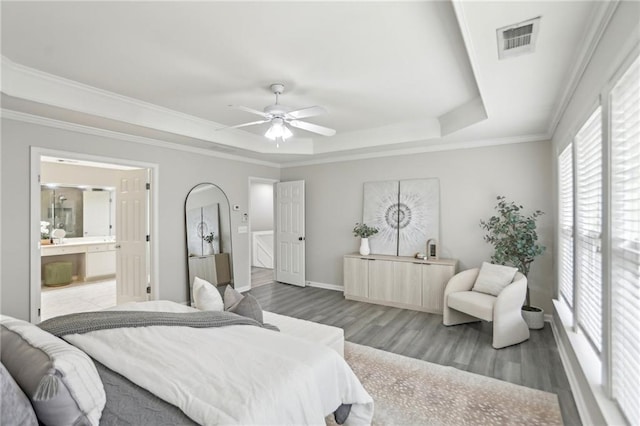 bedroom featuring visible vents, crown molding, ceiling fan, wood finished floors, and a raised ceiling