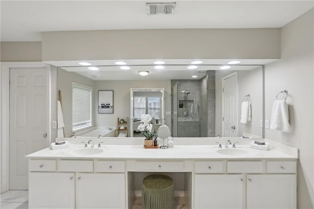 bathroom with visible vents, a sink, a shower stall, double vanity, and a bath