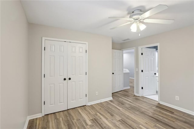 unfurnished bedroom featuring visible vents, wood finished floors, a closet, baseboards, and ceiling fan