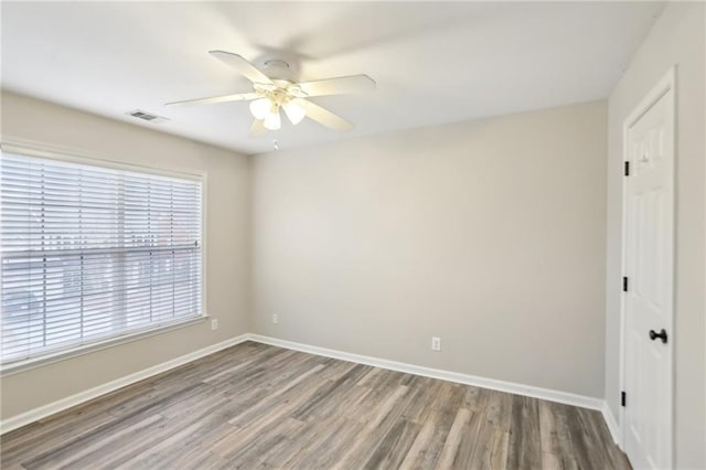 unfurnished room with baseboards, a ceiling fan, and wood finished floors