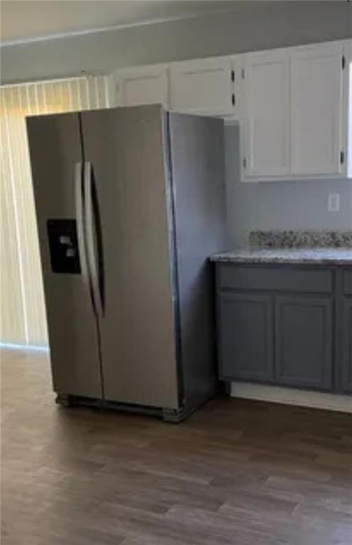 kitchen featuring stainless steel fridge, wood finished floors, and white cabinetry